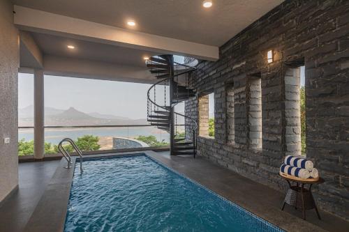 ĀmbavnaSaffronStays Ahilya Waters by Kosha Villas, Pawna - pool villa with panoramic view of Pawna Lake的一座砖墙房子中的游泳池