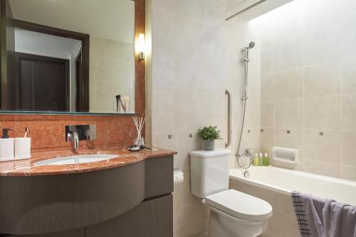 新加坡Somerset Bencoolen Singapore的浴室配有盥洗盆、卫生间和浴缸。
