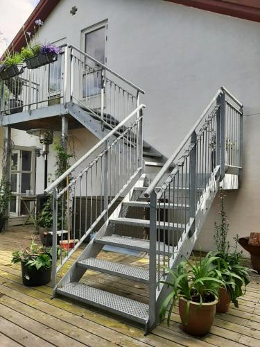 韩德斯泰德The Loft. Studio-apartment in old farmhouse的楼梯通往种有盆栽植物的房子