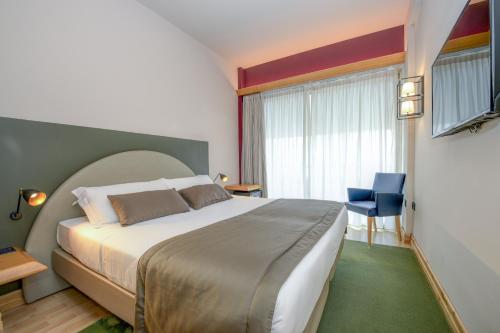 代森扎诺-德尔加达城市酒店的一间设有大床和窗户的酒店客房