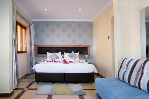 内罗毕West Lerruat Hotel的一间卧室配有一张大床和一张沙发