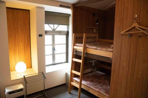 云仙市TSUDOI guest house的客房设有两张双层床和一扇窗户。