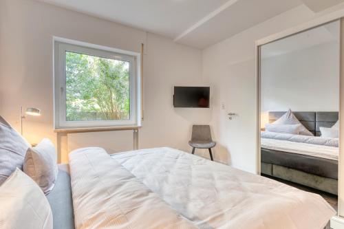 诺德奈Haus Kleemann E24的一间卧室设有一张床、一个窗口和一面镜子