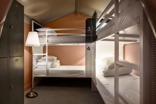 哥本哈根Urban Camper Hostel & Bar的带两张双层床和一盏灯的双层床间