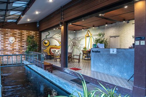 北碧Tarnsiri Boutique Resort的一座带游泳池的房屋和墙上的绘画