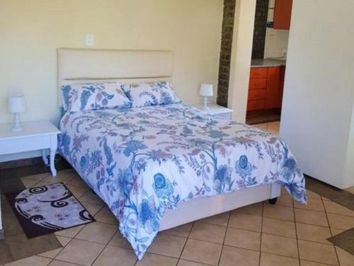 阿尔伯顿Garden Cottage的一间卧室配有一张带蓝色和白色棉被的床