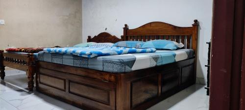 蒙纳Munnar happy holidayss的一张带蓝色枕头的大木床