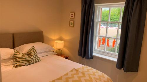 Little BudworthOulton Park Lodge的一间卧室设有一张床和一个窗口