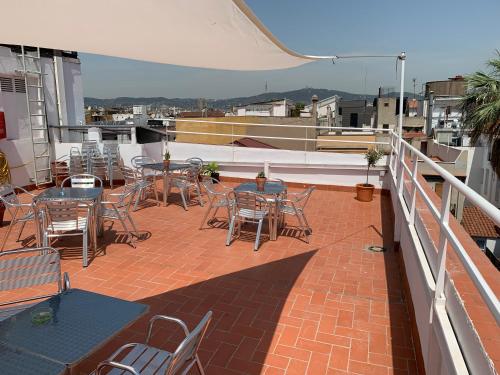 巴塞罗那Hostal La Terrassa的屋顶上带桌椅的天井