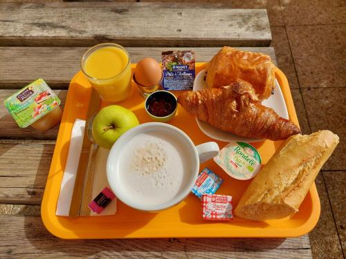 桑特Premiere Classe Saintes的橙色托盘,桌上有早餐食品
