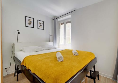 叙雷纳L'HYPERCENTRE de Suresnes的一间卧室配有一张床,上面有两条毛巾
