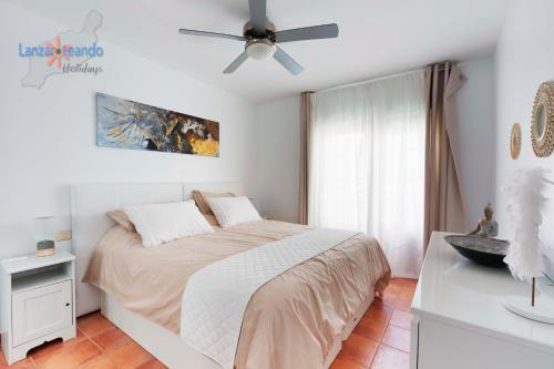 卡列罗港Vivienda Vacacional Casa Shanti的一间卧室配有一张床和吊扇