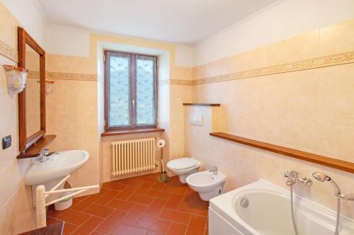 克雷米亚Il Casale di Marnino的浴室配有2个卫生间、浴缸和水槽