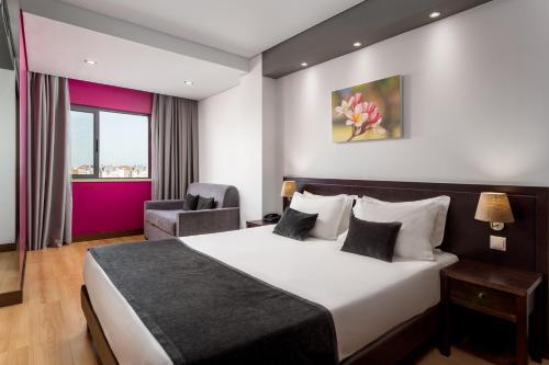 里斯本卢埃纳酒店的配有一张床和一把椅子的酒店客房