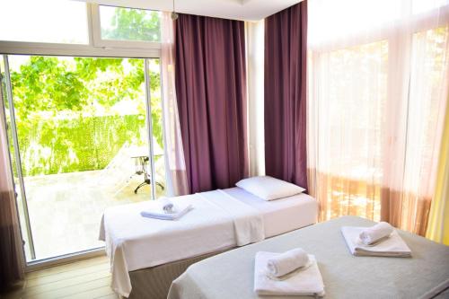 切什梅Balim Sultany的酒店客房设有两张床和大窗户。