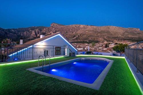 HuesaHotel Sierra de Huesa的一座带绿色草坪的游泳池的房子