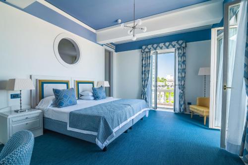 利多迪耶索罗Casa Bianca Al Mare的蓝色的卧室设有床和窗户