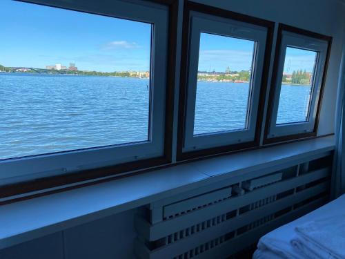 斯德哥尔摩Rygerfjord Hotel & Hostel的船上的两扇窗户俯瞰着水面