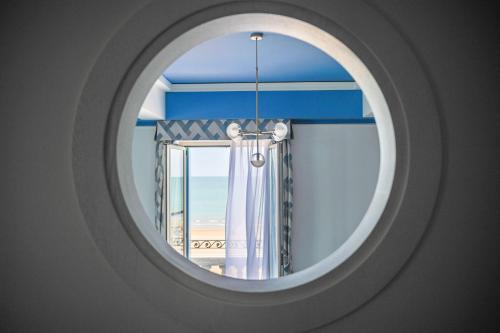 利多迪耶索罗Casa Bianca Al Mare的享有海滩景致的圆形窗户