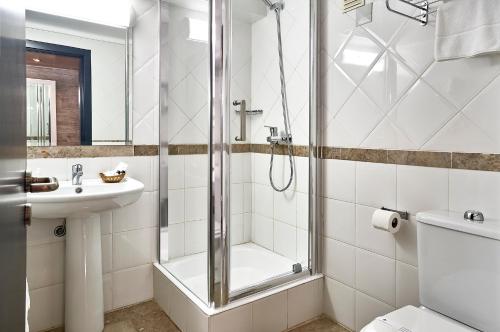 阿威罗Galeria Suite Hotel的带淋浴、卫生间和盥洗盆的浴室