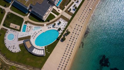 尼基季Ammoa Luxury Hotel & Spa Resort的享有游泳池和水边停车场的顶部景致