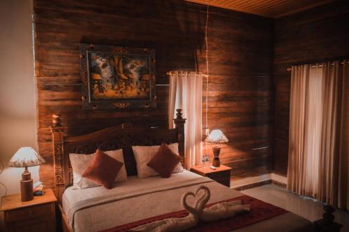 珀尼达岛The Valley Green Cottage的一间卧室配有一张带木墙和两盏灯的床。