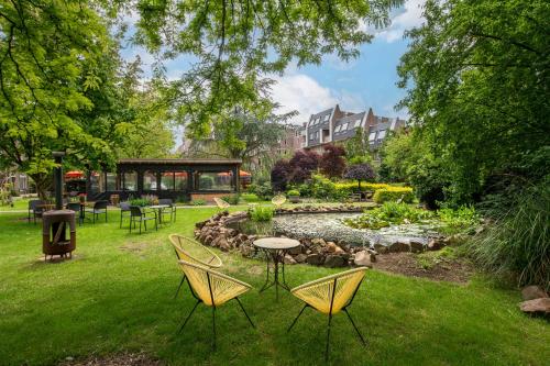 登博斯Kloosterhotel de Soete Moeder的一个带桌椅的花园和一个池塘