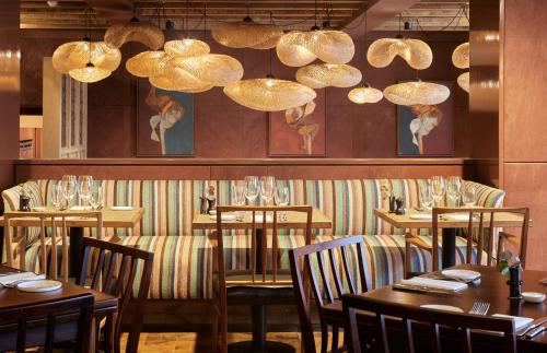 拉伊拉伊的乔治酒店的用餐室配有桌椅和吊灯。