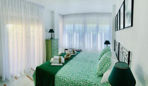 格拉纳达FAISÁN 20 Apartamento的一间卧室配有一张大床和绿色的床罩
