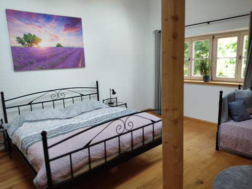 巴特特尔茨Ferienwohnung mit Herz的卧室配有一张床,墙上挂有绘画作品