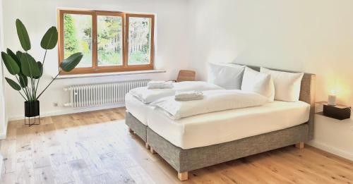 若特阿赫-埃根Bungalow in Rottachs Bestlage的一间卧室配有一张带白色床单的床和一扇窗户。