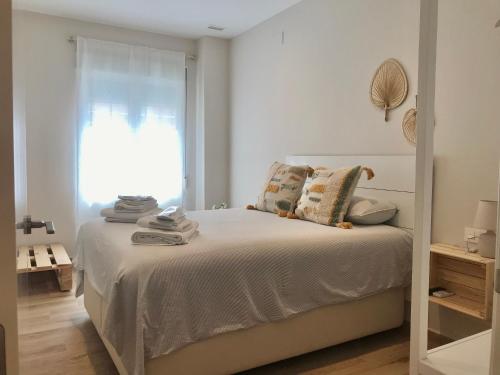 瓦伦西亚Apartamento equipado playa Valencia OnesDeMar的白色卧室设有一张带窗户的床