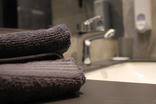 Hotel-VH的浴室水槽顶部的毛巾堆