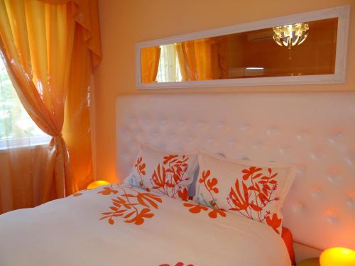 索非亚橙花1号公寓的一间卧室配有带橙色窗帘和镜子的床