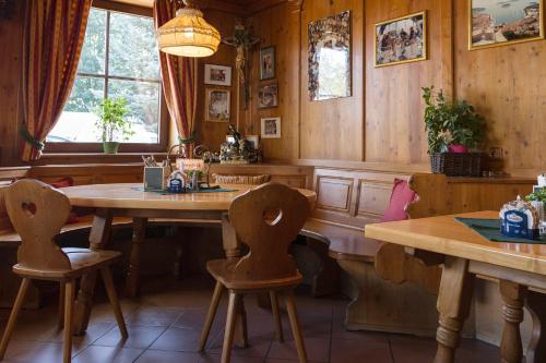 AigelsbachLandgasthof Kammerhof的用餐室设有木墙和桌椅