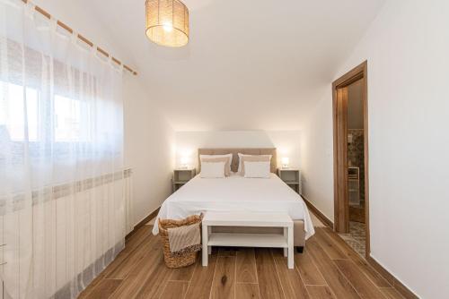 罗维尼Guest house DaLi的白色卧室配有床和桌子