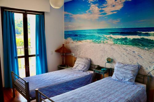 蓬特拉雷纳Albergue Puente para peregrinos的一间带两张床的卧室和海洋壁画