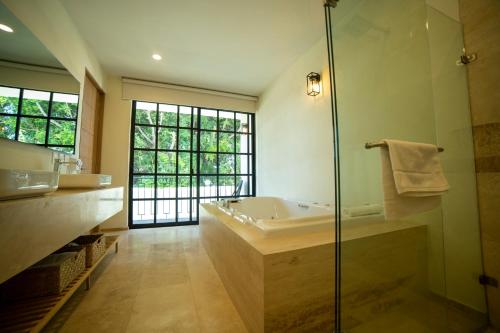 瓜达拉哈拉Hotel Dex Tlaquepaque的带浴缸和玻璃淋浴间的浴室。