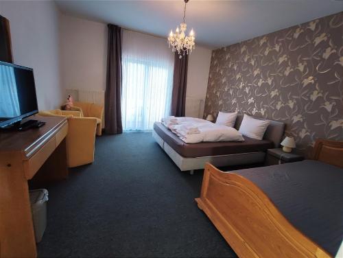 温特贝格Berghotel Natura Bed & Breakfast的酒店客房配有床、沙发和电视。