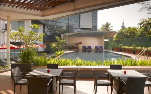 雅加达雅加达美利亚酒店&度假村的一个带桌椅的户外庭院和一个游泳池