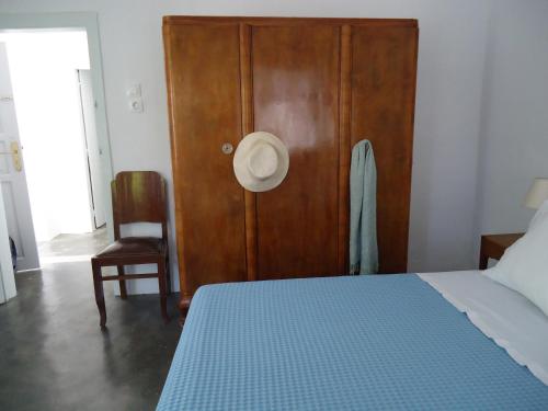 KórinthosAνεξάρτητη παραδοσιακή πέτρινη κατοικία的一间卧室配有一张床、一扇木门和一把椅子