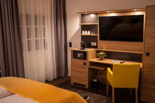 HabyLandgasthof Lehmsiek的酒店客房配有书桌和电视。