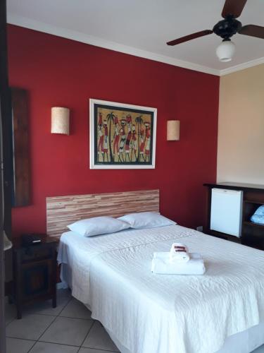 帕拉蒂Pousada Estacao do Sol de Paraty的卧室配有白色的床铺和红色的墙壁