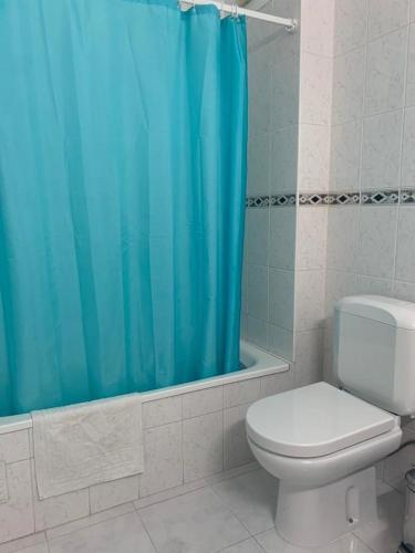 蒙蒂戈杜Apartamento T1 Monte Gordo的浴室设有卫生间和蓝色的浴帘。