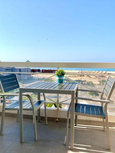 蒙蒂戈杜Apartamento T1 Monte Gordo的一张桌子和椅子,享有海滩美景