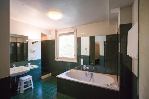 特伦托布里科斯里昂酒店的带浴缸和盥洗盆的大浴室