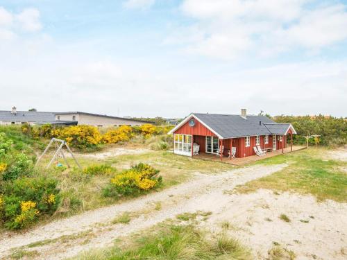 Nørre Lyngvig6 person holiday home in Hvide Sande的田间中的一个红色房子