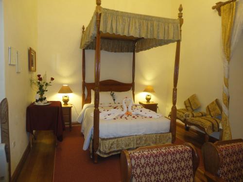 库斯科绿色酒店的一间卧室配有一张天蓬床和一把椅子