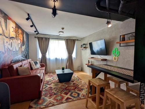 CaintaCozy 1BR Loft for Visiting Families in Cainta Wifi的客厅配有沙发和桌子