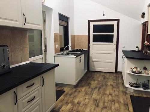 Sebeşu de SusCasa Ardeleneasca的厨房配有白色橱柜和黑色台面